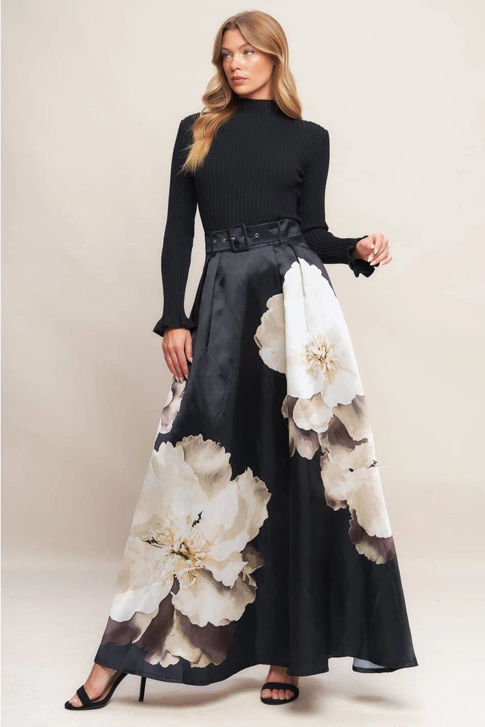 Woman wearing a black dress with floral patterns on a plain background