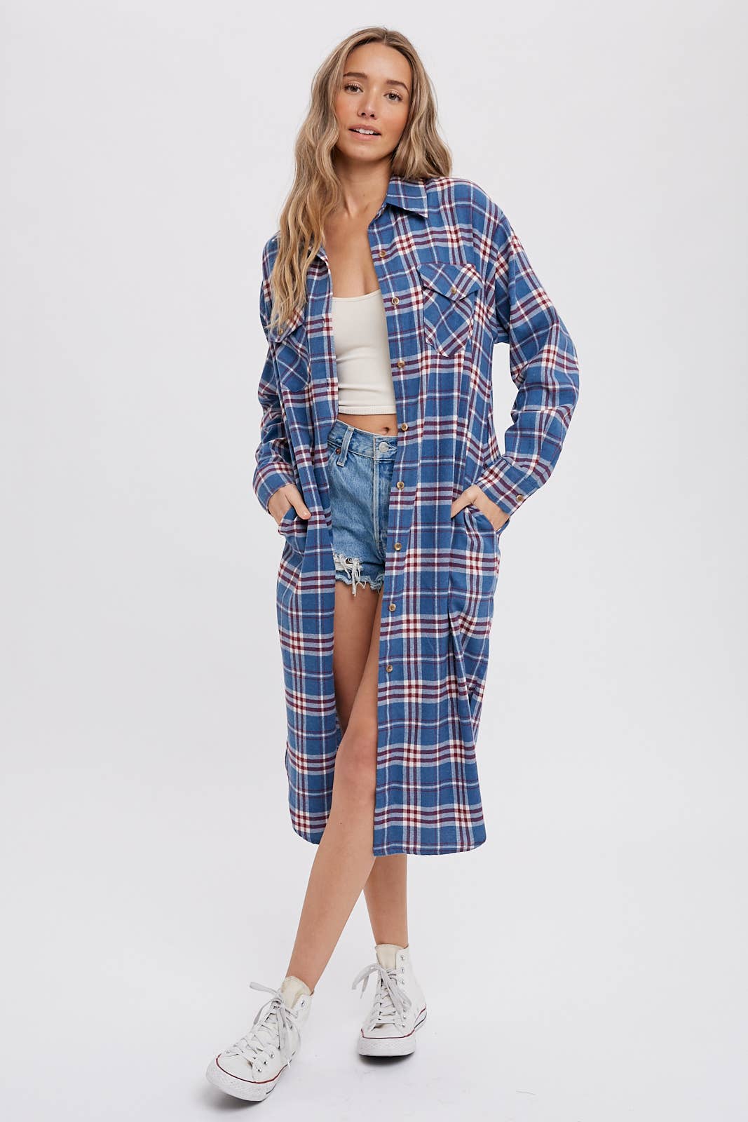 Woman wearing a blue plaid shirt dress with a white background