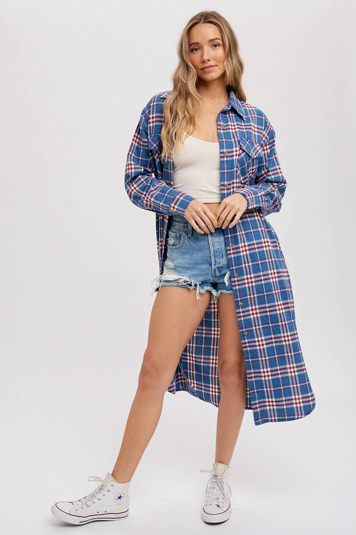 Woman wearing a blue plaid shirt over a white top and denim shorts on a white background