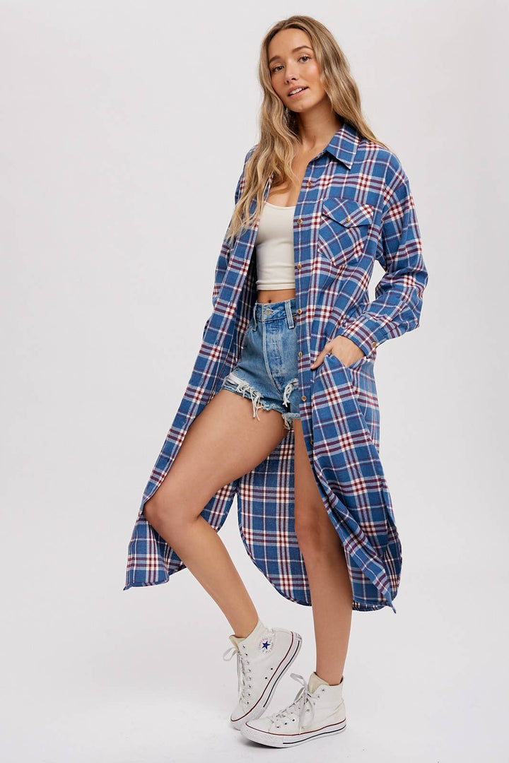 Woman wearing a long blue plaid shirt over a white top and denim shorts on a white background