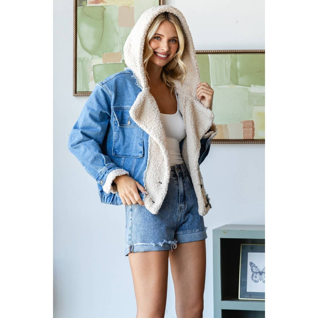 Woman wearing a denim jacket with a sherpa lining indoors