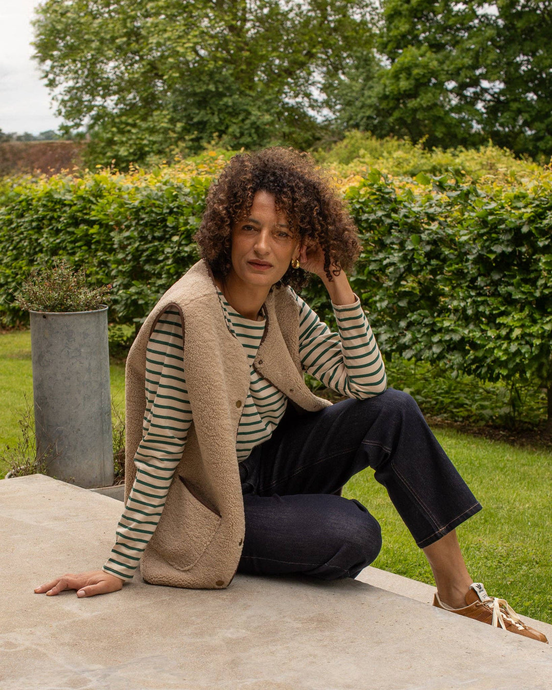 Woman sitting outdoors in a garden setting