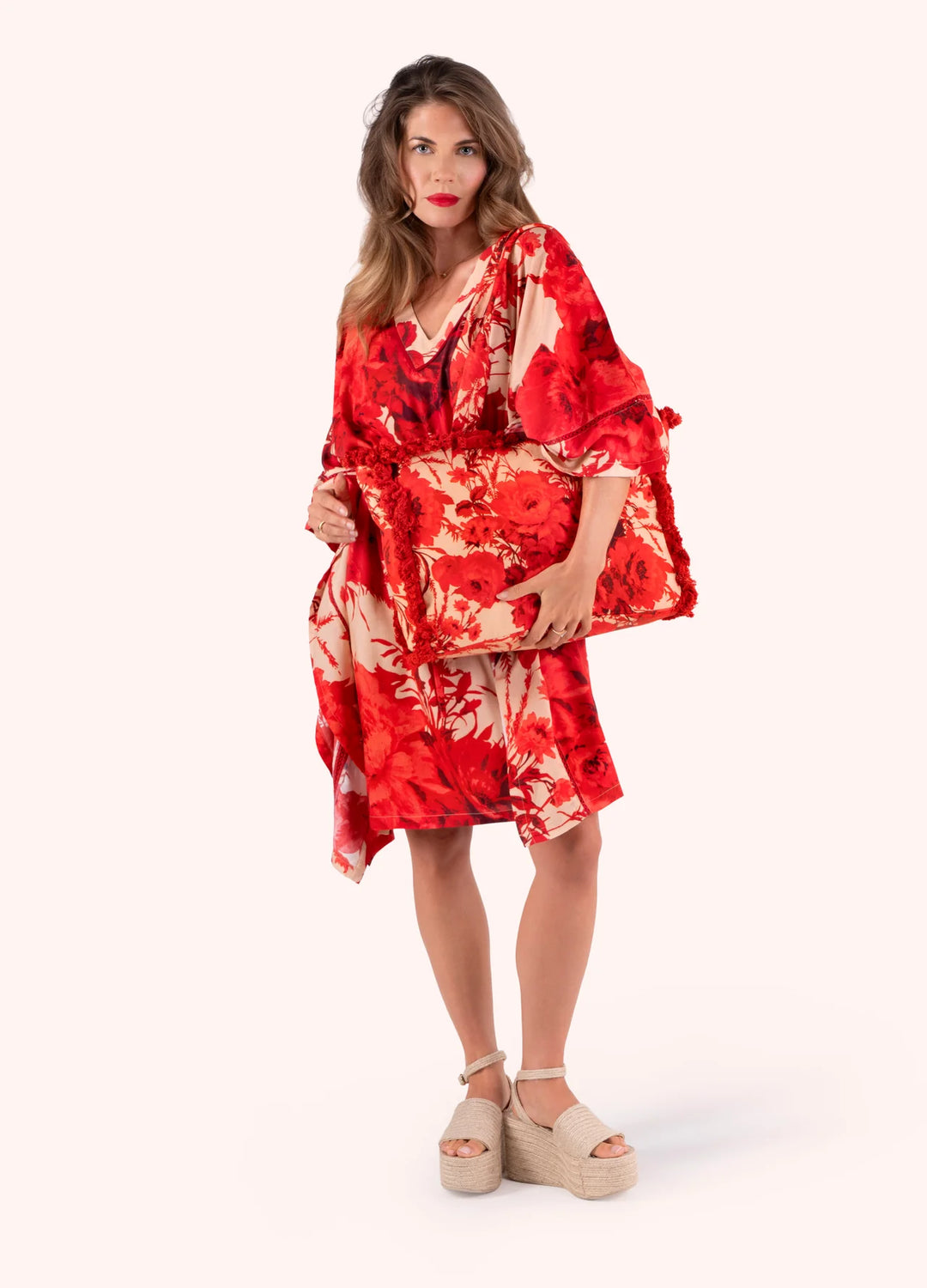 Woman wearing a red floral dress on a white background