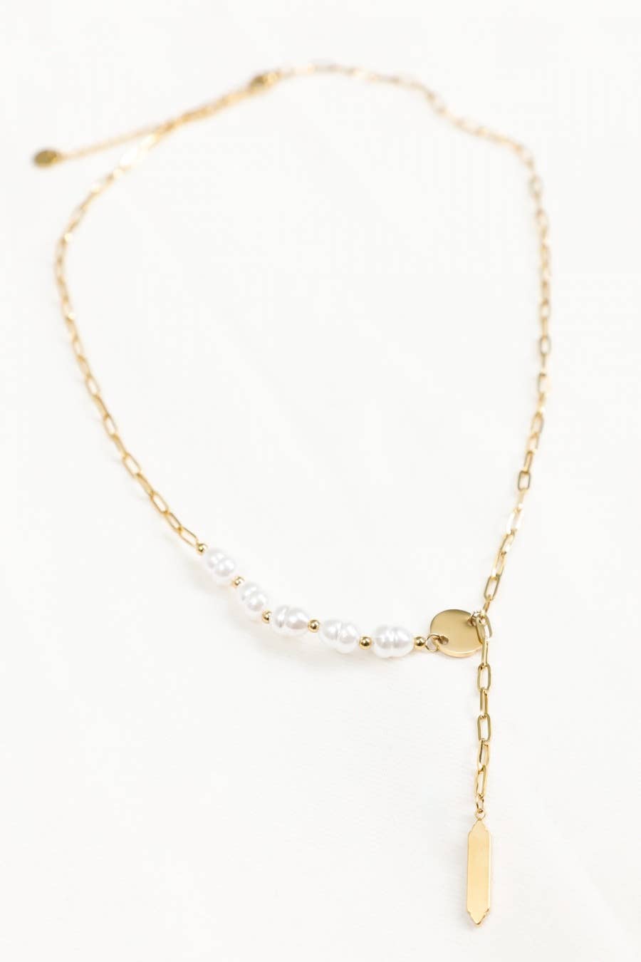 Gold necklace with pearl beads on a white background