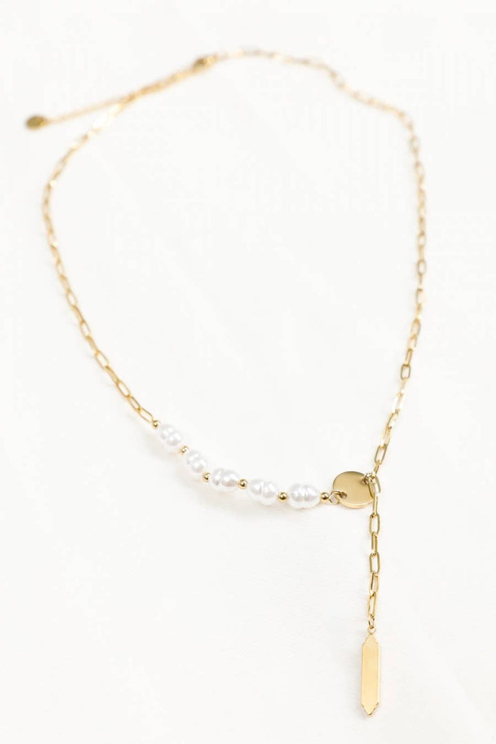 Gold necklace with pearl beads on a white background