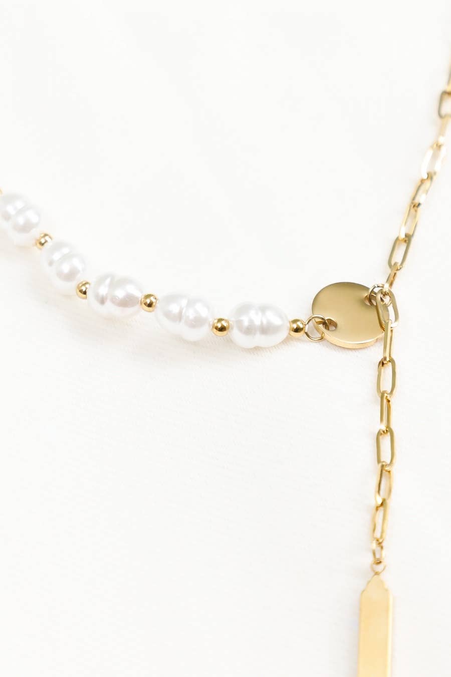 Gold necklace with pearl beads on a white background