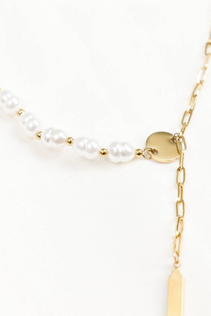Gold necklace with pearl beads on a white background