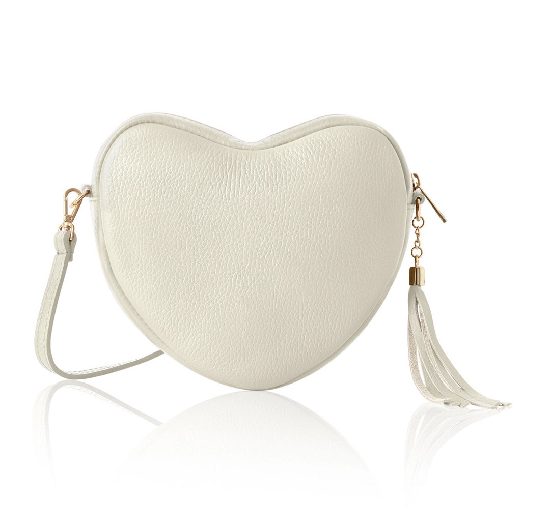 Heart-shaped cream-colored handbag with a tassel on a white background