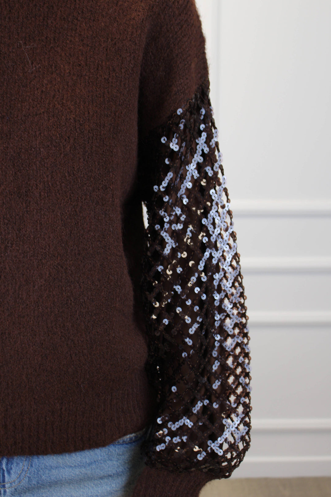Brown sweater with sequin sleeves on a white background