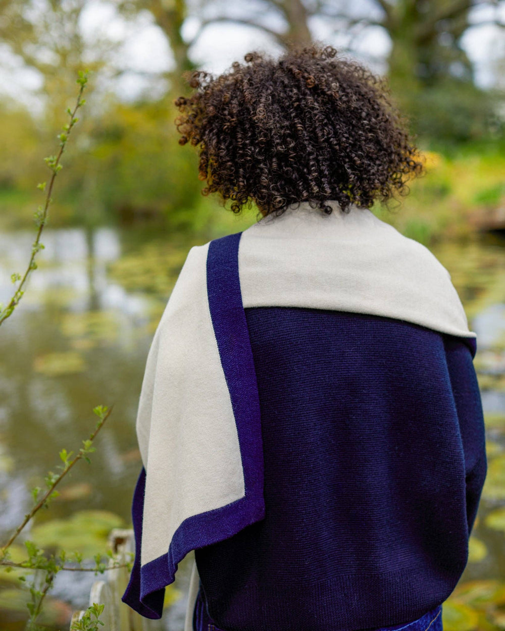 Person wearing a blue and white shawl in a natural setting