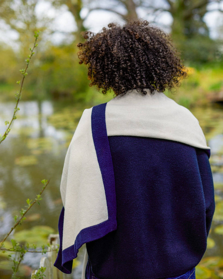 Person wearing a blue and white shawl in a natural setting