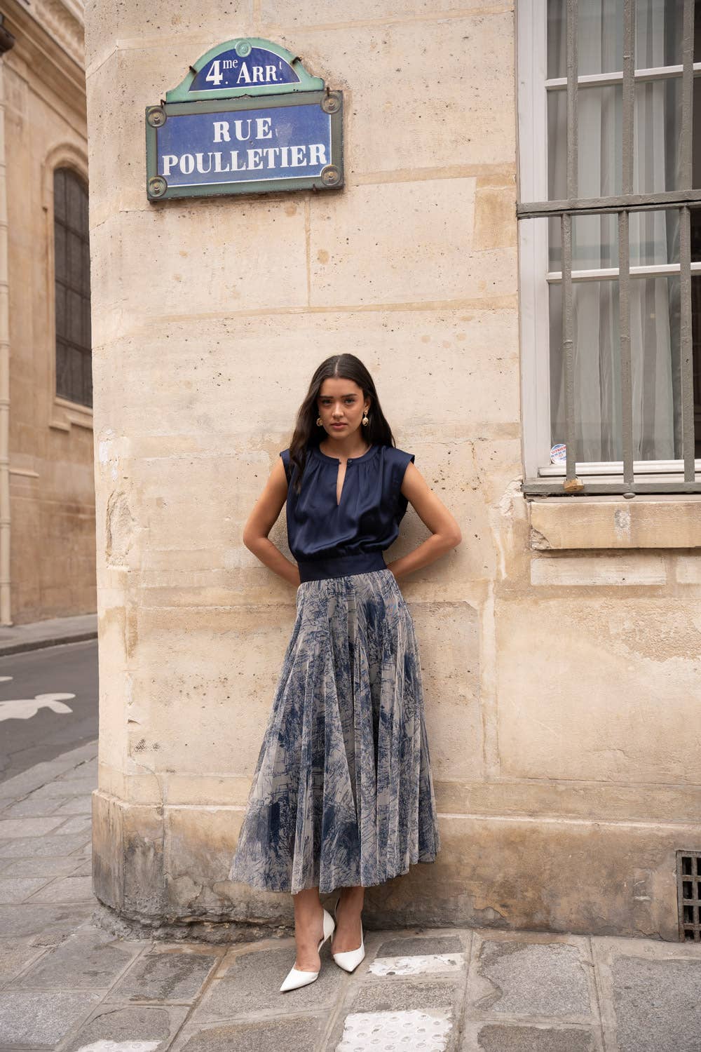 Woman standing against a building with a street sign in the background