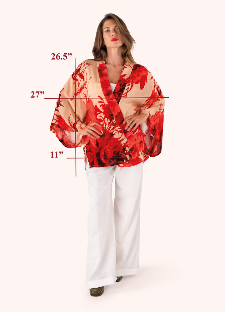 Woman wearing a red and beige floral kimono with measurements indicated on a white background