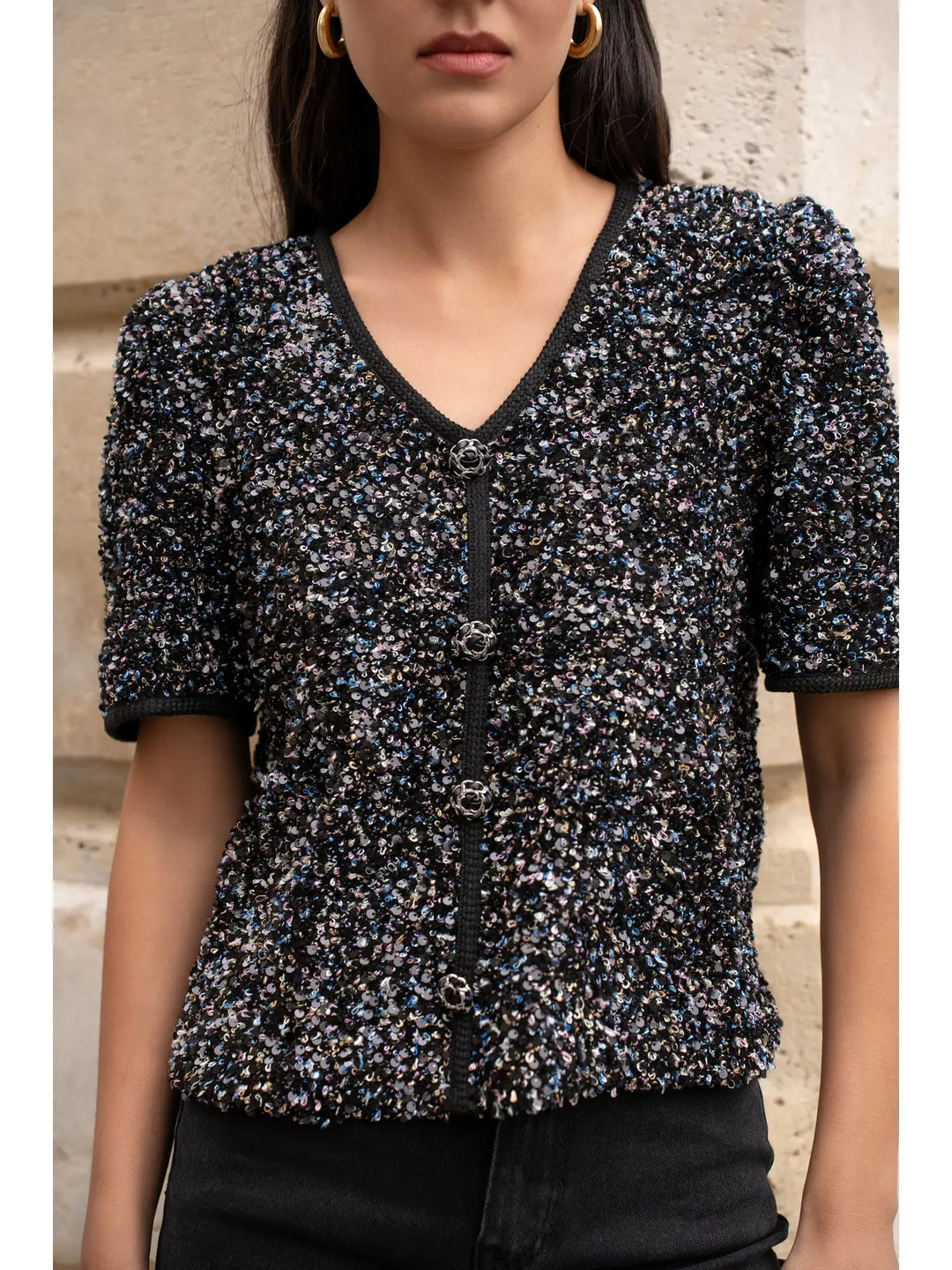 Woman wearing a black and blue patterned top with a neutral background