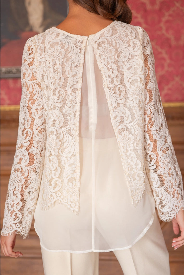 White lace top worn by a person with a blurred background