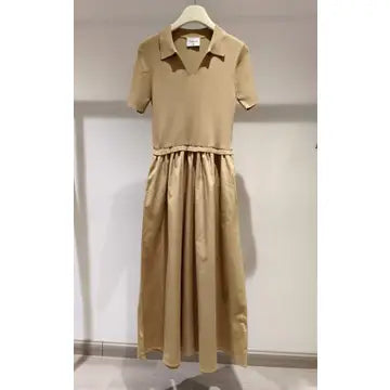 Beige dress on a hanger against a plain background