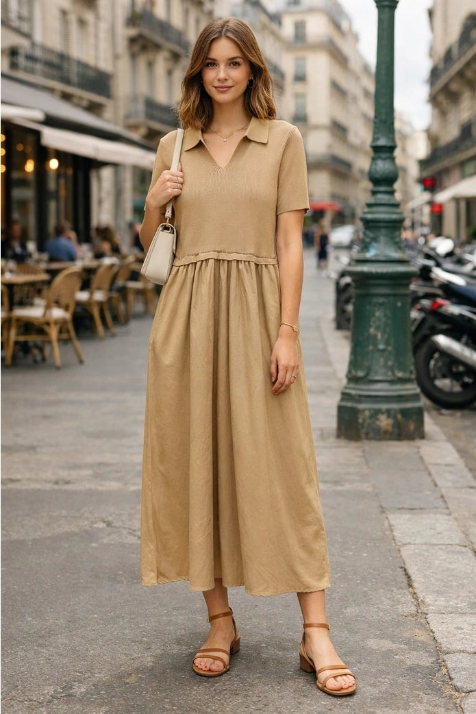 Woman in a beige dress standing on a city street.