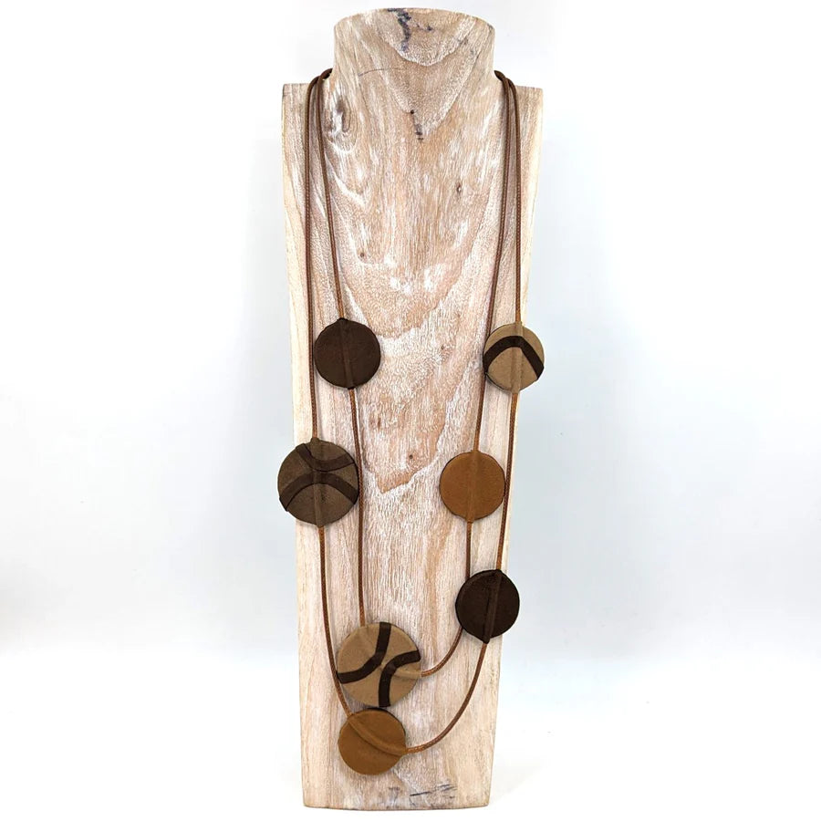 Wooden wall art with circular brown accents on a white background
