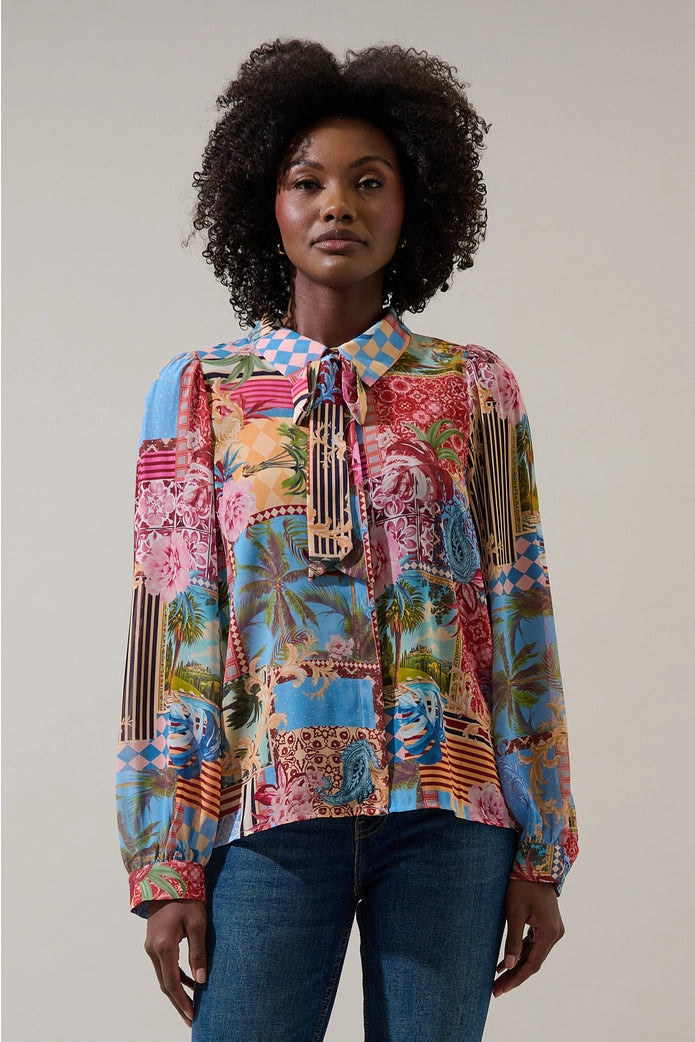 Woman wearing a colorful patchwork blouse against a plain background