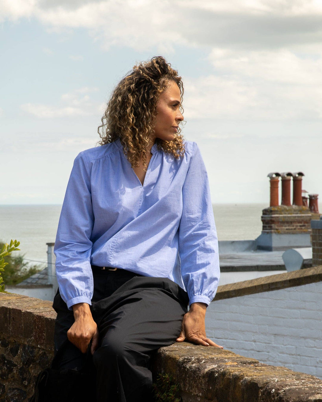 Person sitting on a ledge with a scenic background