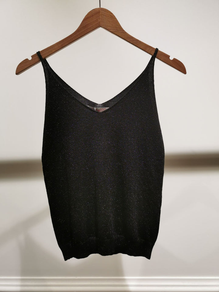 Black tank top on a wooden hanger against a white background