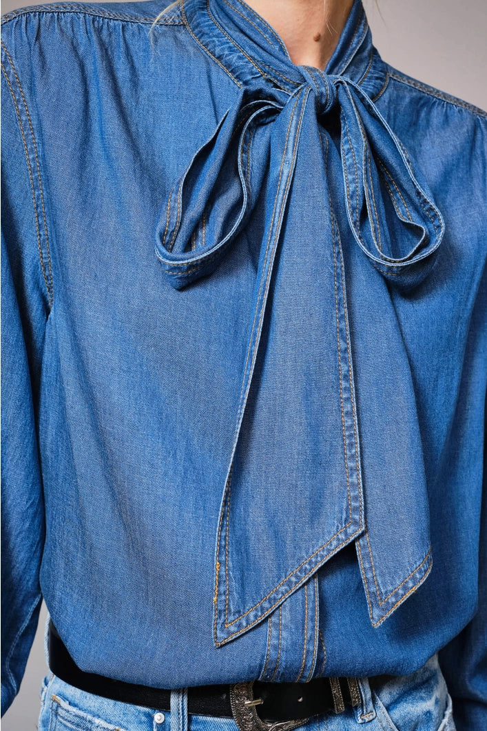 Blue denim shirt with a tie detail on a plain background