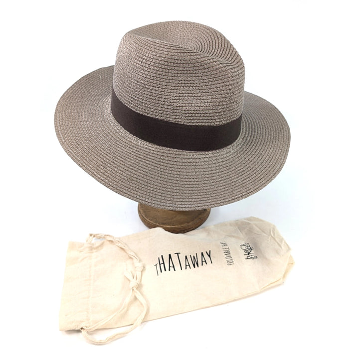 Gray straw hat with a black band on a wooden stand, accompanied by a beige carrying bag labeled 'THATaway' on a white background.