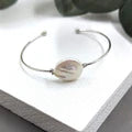 Silver bracelet on a white surface