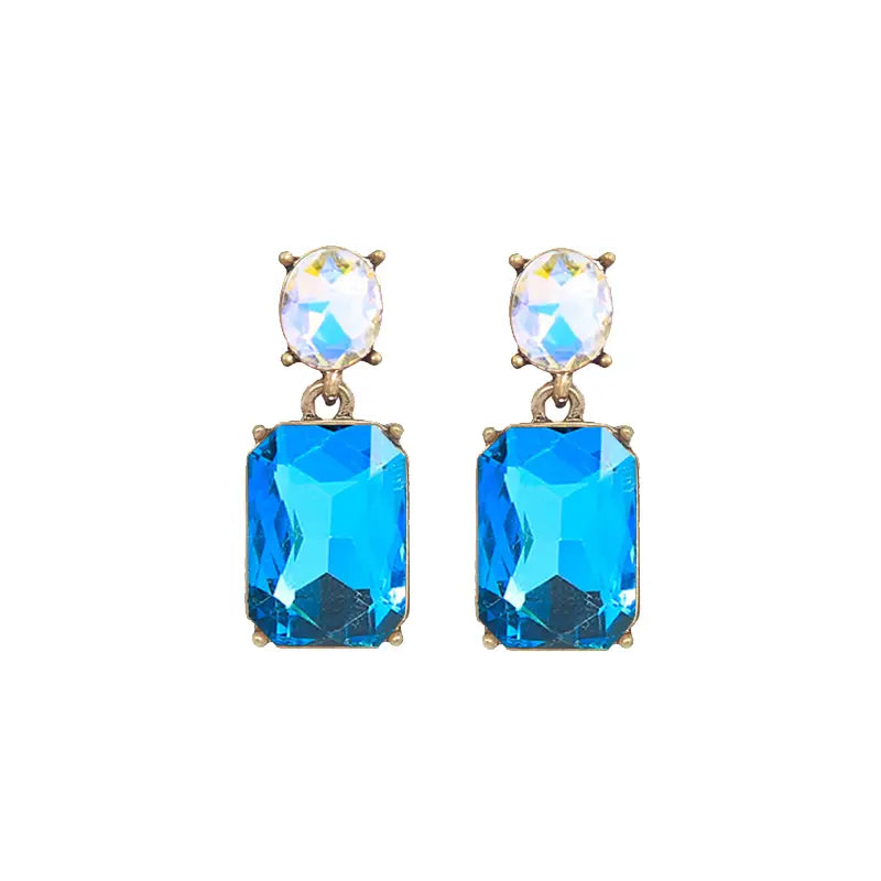 Pair of earrings with blue gemstones and gold accents on a white background