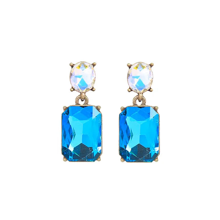 Pair of earrings with blue gemstones and gold accents on a white background