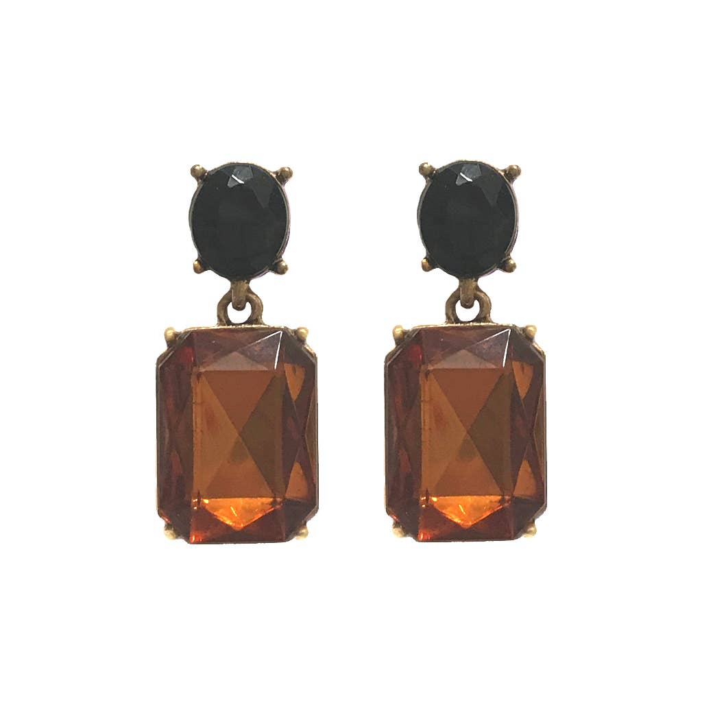Pair of earrings with black and orange gemstones on a white background