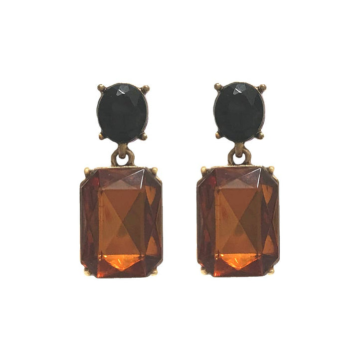 Pair of earrings with black and orange gemstones on a white background