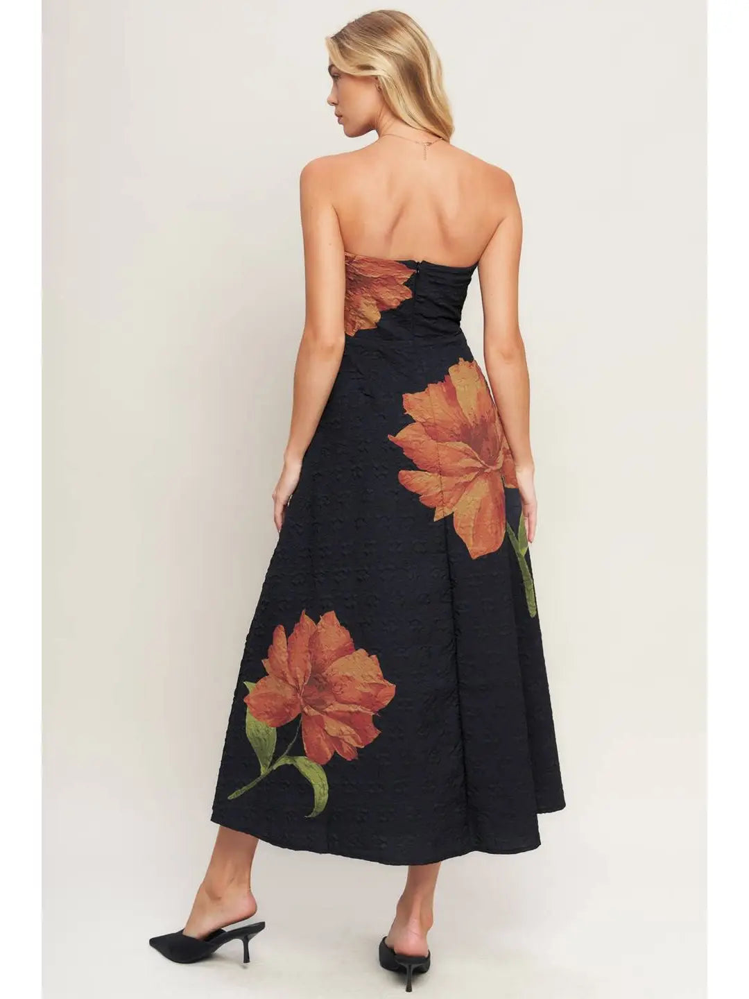 Black strapless dress with large floral patterns on a white background