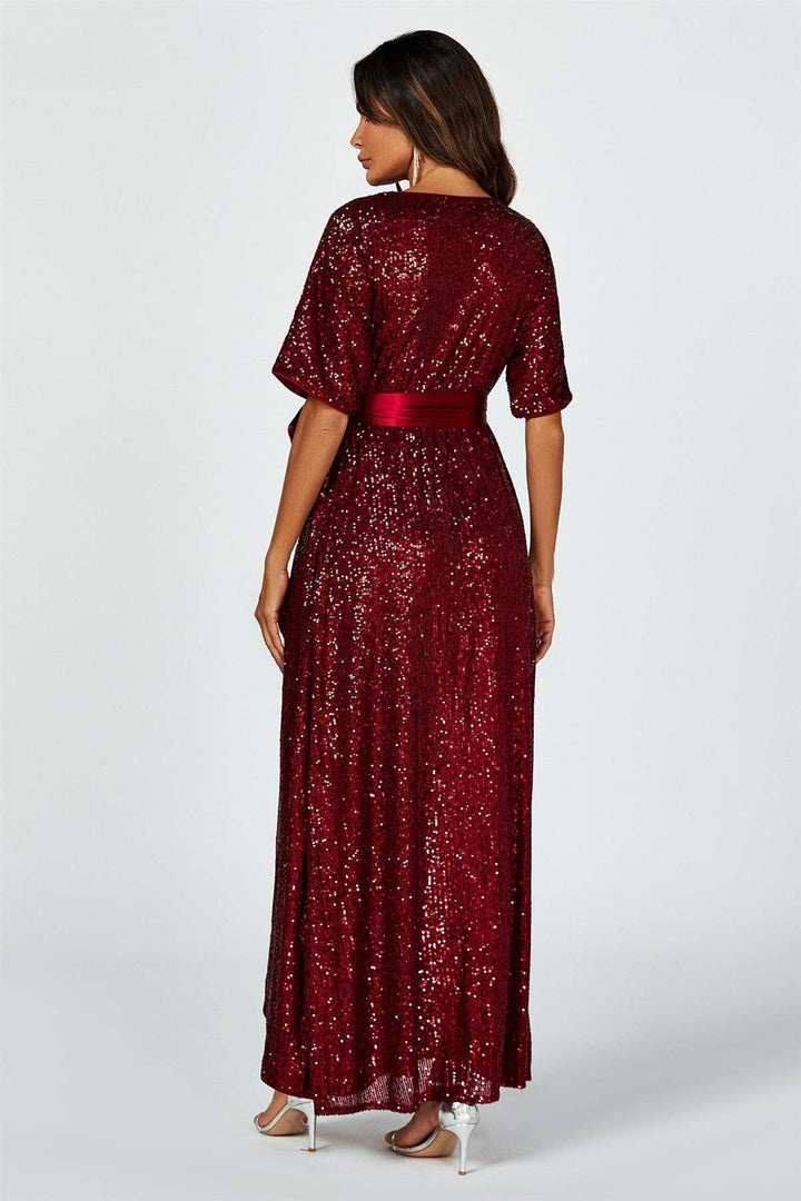 Woman wearing a burgundy sequin dress on a white background