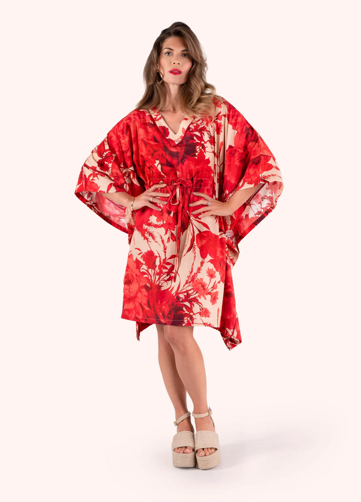 Woman wearing a red and white floral dress on a white background