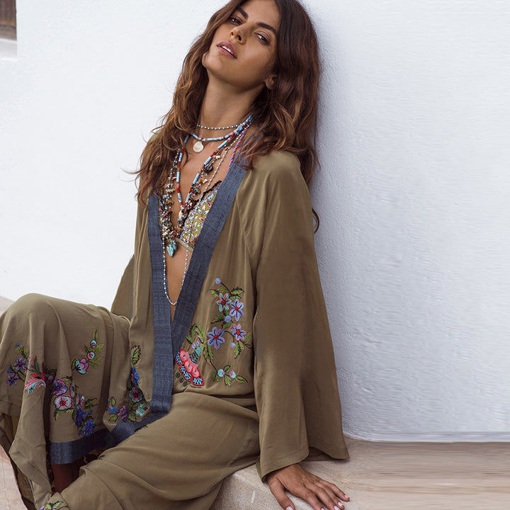 Woman wearing an embroidered outfit against a white wall