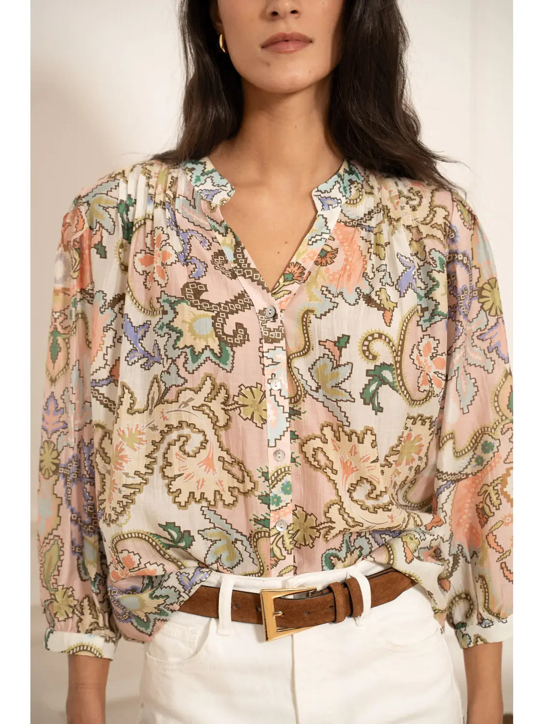 Woman wearing a floral blouse with a neutral background