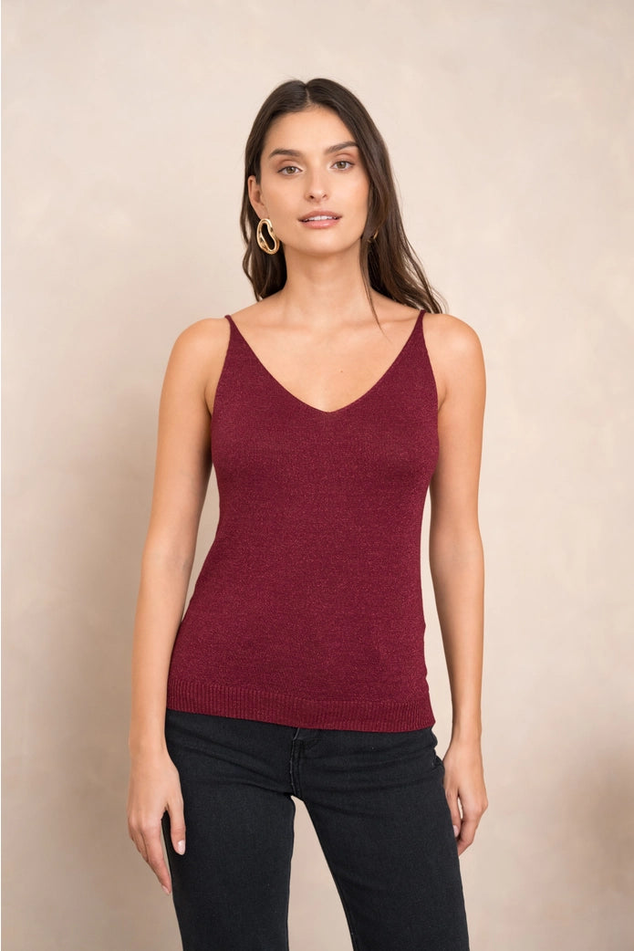 Woman wearing a burgundy tank top against a beige background