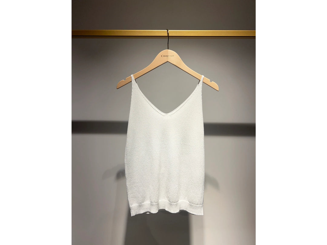 White tank top on a wooden hanger against a gray background