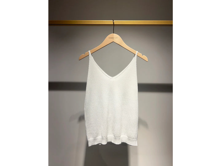 White tank top on a wooden hanger against a gray background