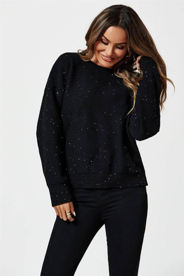 Woman wearing a black sweater with small patterns on a white background