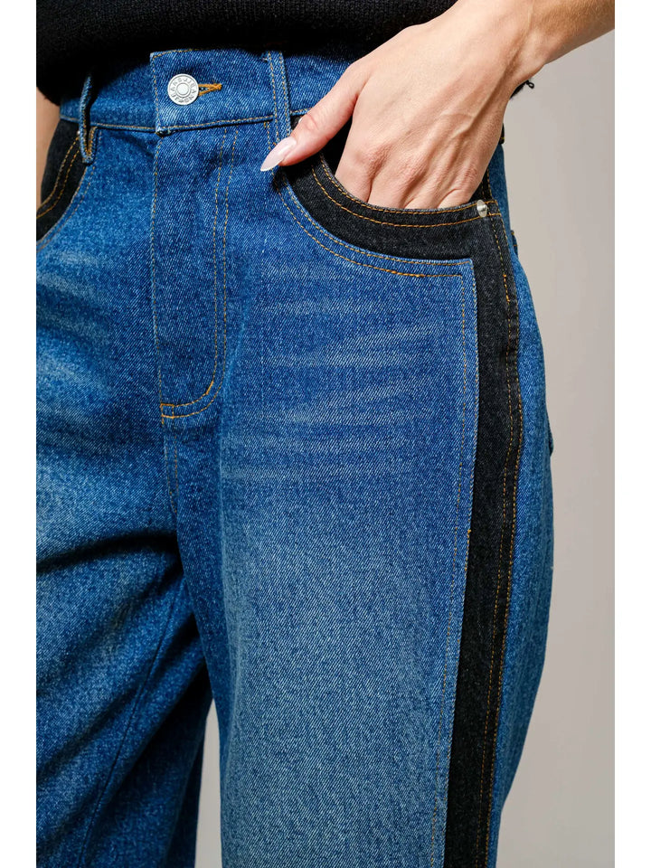 Blue jeans with a black stripe on a neutral background
