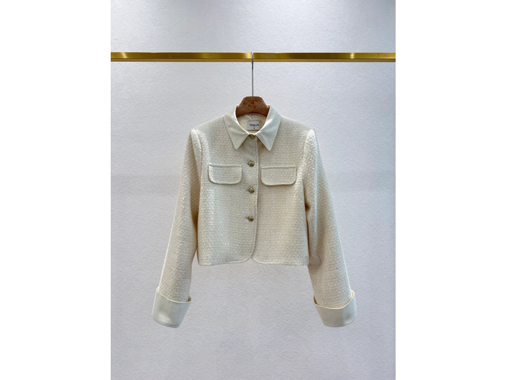 White textured jacket on a hanger against a light gray background