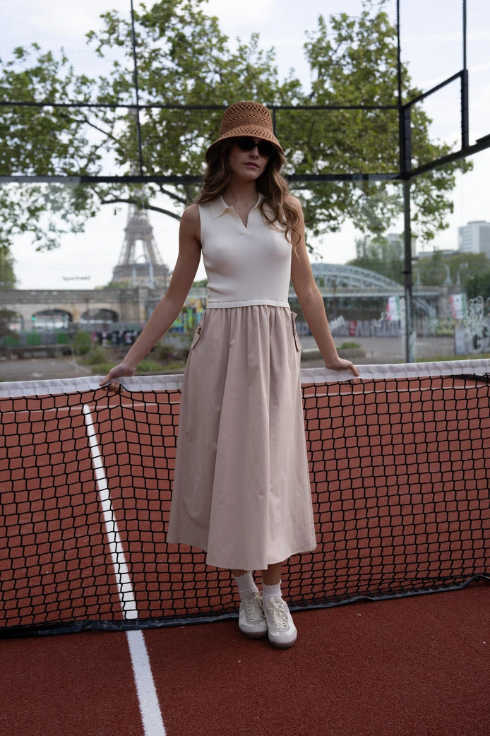Woman standing on a tennis court with the Eiffel Tower in the background