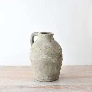 Textured ceramic vase on a wooden surface with a white background
