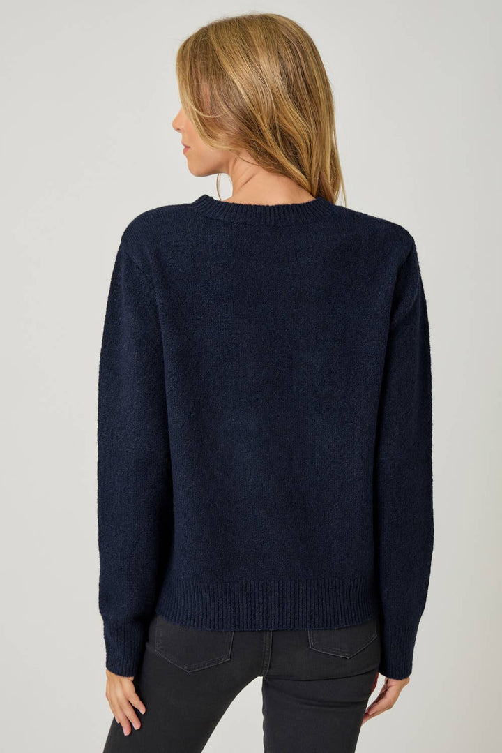 Person wearing a navy blue sweater on a plain background