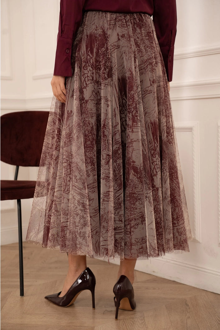 Person wearing a patterned skirt and high-heeled shoes indoors.