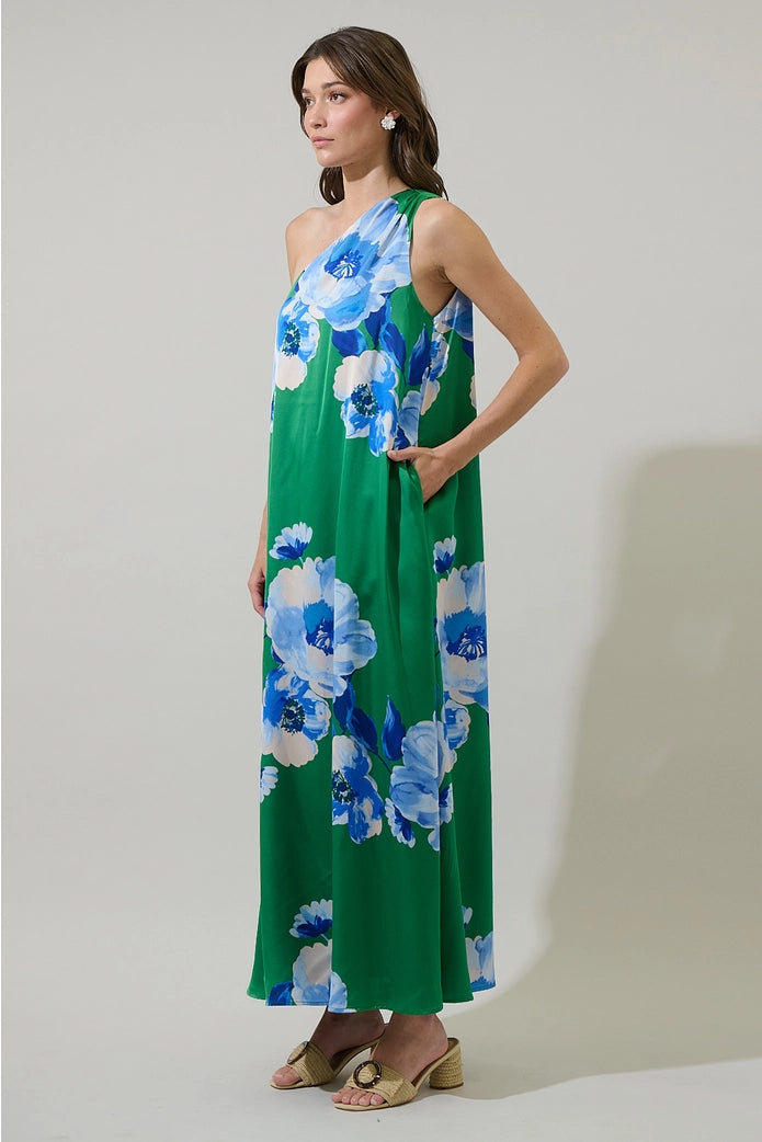 Woman wearing a green floral dress against a plain background