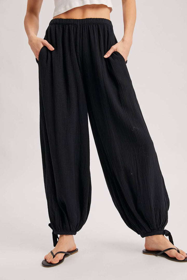 Black wide-leg pants worn by a person on a white background