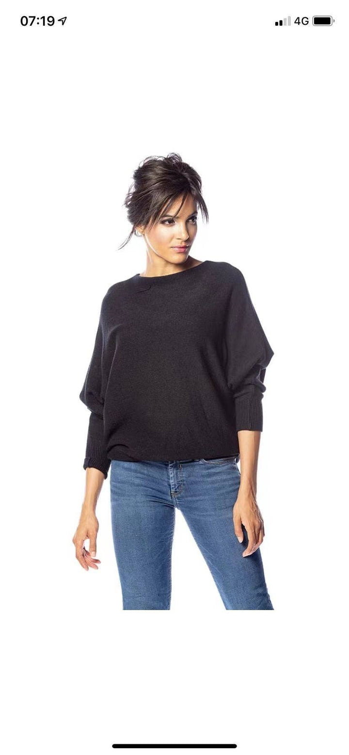 Woman wearing a black sweater and blue jeans on a white background